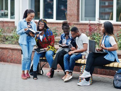 group-five-african-college-students-spending-time-together-campus-university-yard-black-afro-friends-studying-bench-with-school-items-laptops-notebooks